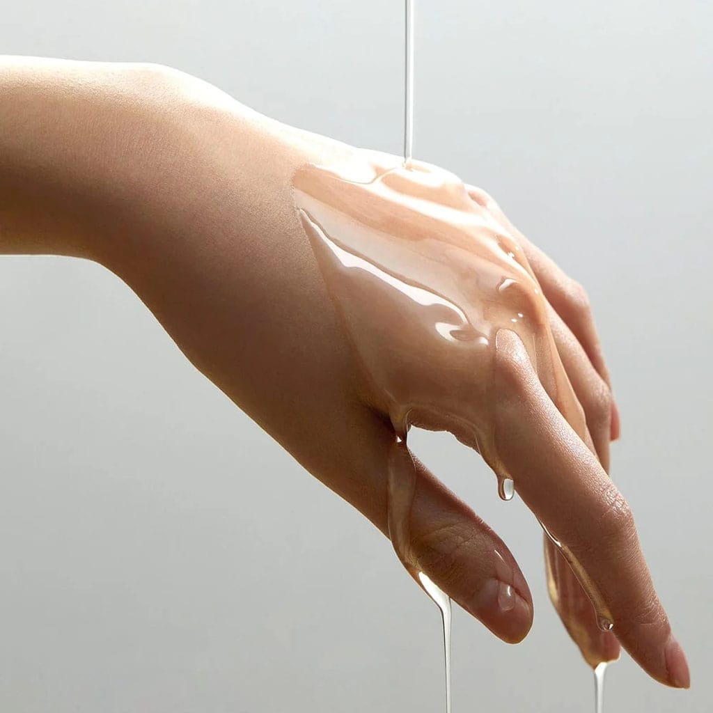 Anua Heartleaf Pore Control Cleansing Oil – Huile démaquillante fluide s’écoulant sur le dos d’une main, illustrant sa légèreté, son pouvoir nettoyant et son absorption rapide sans effet gras.